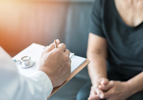 Doctor writing on a clipboard while a patient talks